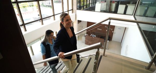 Hall interno do Foccus Workplace, com escada, mezanino e profissionais circulando entre os andares.
